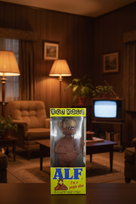 Wacky Wobbler ALF figure in its original packaging, featuring a brown furry alien character with a beige face and white teeth, set against a bright yellow and blue box with 'Wacky Wobbler' and 'ALF' branding.