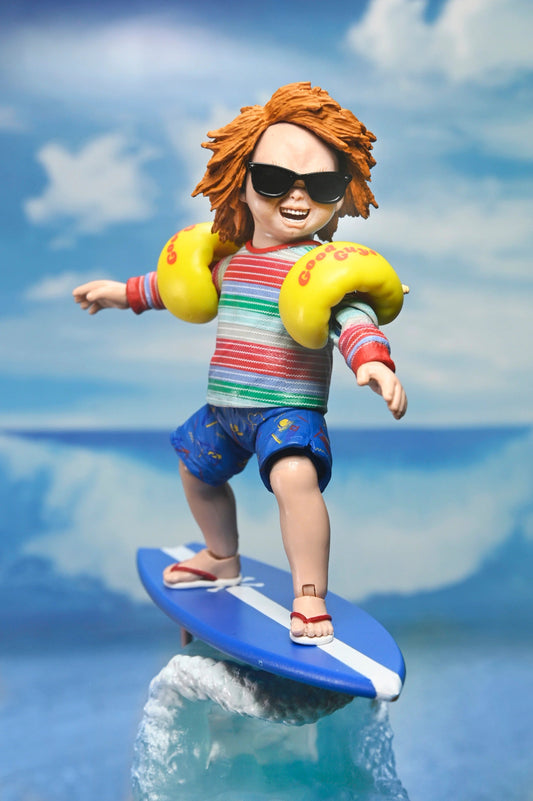 Kings Vault Collectibles NECA Ultimate Surf's Up Chucky figure wearing sunglasses and arm floaties on a surfboard